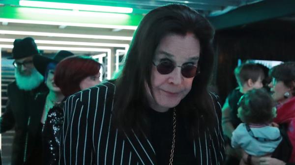 Ozzy Osbourne walking with cane